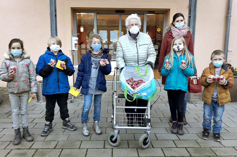 Kinder der Offenen Ganztagsschule (OGS) Giershagen brachten viele rote Pakete ins Altenheim St. Clara. Darüber freute sich auch Elisabeth Aniol (Vorsitzende des Bewohnerbeirates). Foto: ahfr